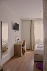 a bedroom with a bed and a table and a mirror at Hotel Luna in Međugorje +54 photos