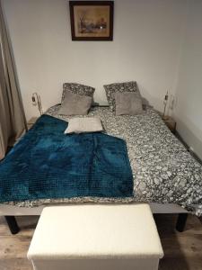 a bedroom with a bed with a blue blanket on it at L'Escapade Vierzonnaise in Vierzon