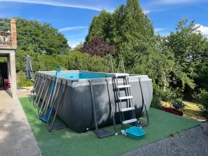a pool with a ladder and a swing set at L'Escapade Vierzonnaise in Vierzon