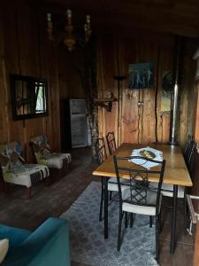 a dining room with a wooden table and chairs at Cabaña Refugio Rustica in Pucón