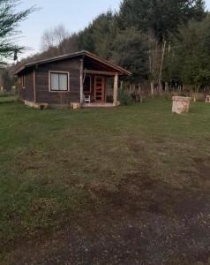 a small house in a field with a yard at Cabaña Refugio Rustica in Pucón +14 photos