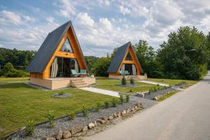a small house with a black roof on a field at Rzav A - Frames in Arilje
