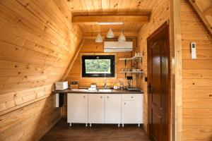 a kitchen in a log cabin with a sink and a window at Rzav A - Frames in Arilje +73 photos