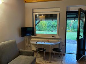 a living room with a table and chairs and a window at k.e.m.p. inn in Krzycko Małe