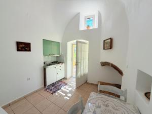 eine Küche mit weißen Wänden, einem Tisch und Stühlen in der Unterkunft Volta Stonehouse Apartments in Frátsia