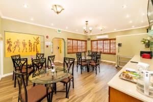 a kitchen and dining room with tables and chairs at Culture Crossroads Inn in Port-of-Spain