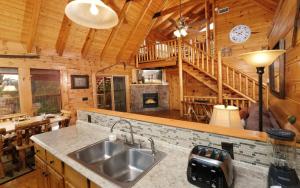 a kitchen with a sink and a fireplace in a log cabin at Calis Place in Sevierville