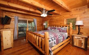 a log cabin bedroom with a bed and a ceiling fan at Calis Place in Sevierville +78 photos