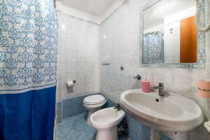 a bathroom with a sink and a toilet and a mirror at Appartamento Centrale in Ischia Town
