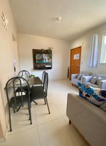a living room with a table and a couch at Apto Aconchego no Coração de Capitólio condomínio residencial in Capitólio