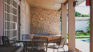 a patio with chairs and tables and a stone wall at Cabañas de Asgard in Nueva Gorgona