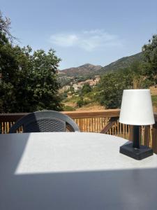 a lamp sitting on top of a table on a deck at Chalet en Corse in Santa-Maria-Figaniella +1 photo