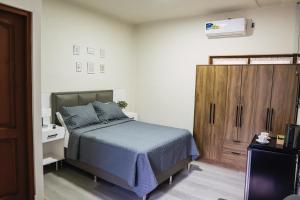 a bedroom with a bed and a wooden cabinet at Hotel Boutique La Casona in Tarija