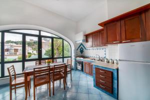 a kitchen with a table and chairs and a large window at Appartamento Centrale in Ischia Town