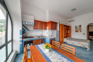 a kitchen with a table and a room with a bed at Appartamento Centrale in Ischia Town