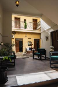a living room with tables and benches in a building at Hotel Boutique La Casona in Tarija