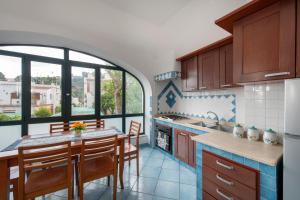 a kitchen with wooden cabinets and a table with chairs at Appartamento Centrale in Ischia Town +30 photos