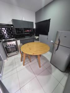 a kitchen with a wooden table and a refrigerator at Arena blanca in Fiambalá