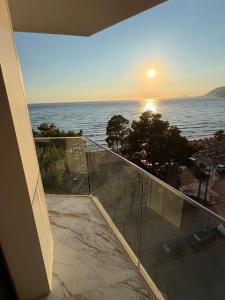 a balcony with a view of the ocean at sunset at Blue luxury apartment Kune in Sakës