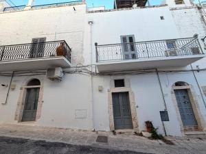 a white building with two balconies and a balcony at Casa Maresca in Ostuni