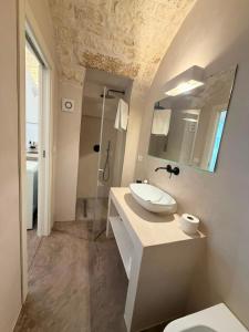 a white bathroom with a sink and a shower at Casa Maresca in Ostuni +18 photos