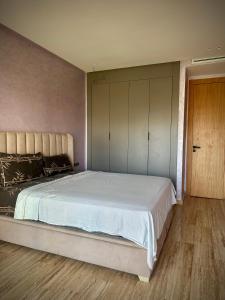 a bedroom with a large bed and a wooden floor at Relaxing residence oceanic Sidi rhal in Sidi Rahal +11 photos