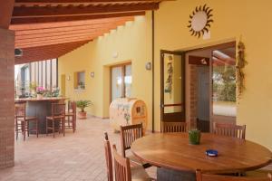 a dining room with a table and chairs and a counter at Agriturismo Pituello in Talmassons