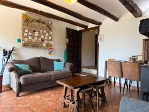 a living room with a couch and a table at Albergue OasisTrails for pilgrims on Camino de Santiago in Villamayor de Monjardín