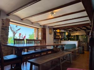 a dining room with a wooden table and benches at Albergue OasisTrails for pilgrims on Camino de Santiago in Villamayor de Monjardín