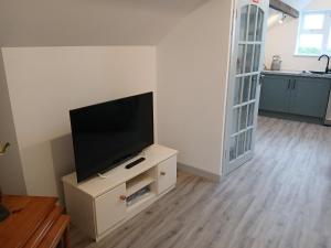 a living room with a flat screen tv on a cabinet at Roshinehill apartment in Shanbally +2 photos
