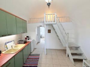 eine Küche mit Spüle und Wendeltreppe in der Unterkunft Volta Stonehouse Apartments in Frátsia