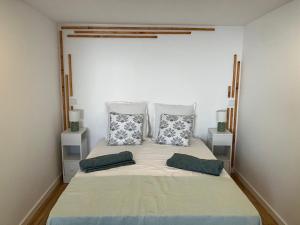 a bedroom with a large bed with two pillows at Casa do Brasileiro in Arco da Calheta