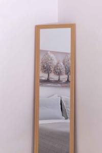 a mirror with a picture of trees on a wall at Angie's House Volos in Volos