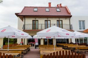 a group of tables and umbrellas in front of a building at JULA Pokoje Blisko Plaży, Dąbki in Dąbki