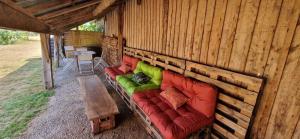 a couch sitting inside of a wooden building at Les chambres de Mona in Tauriac