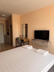 a bedroom with a large bed with a flat screen tv at Студио Морски бриз in Sozopol