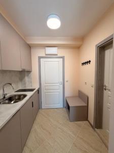 a kitchen with a sink and a white door at Студио Морски бриз in Sozopol