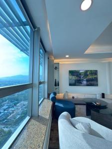 a living room with a table and a large window at The Premier Centauras in Islamabad