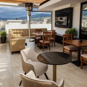 a restaurant with a table and chairs and a couch at Hotel Caluva in Loja