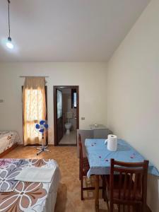 a room with a table and chairs and a bathroom at General's Beach House in Kavajë