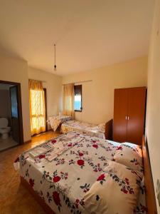a bedroom with a bed with a floral bedspread at General's Beach House in Kavajë