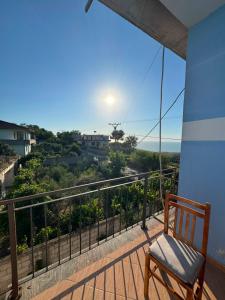 a chair on a balcony with a view of the ocean at General's Beach House in Kavajë