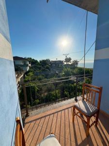 a chair on a balcony with a view of the ocean at General's Beach House in Kavajë +13 photos