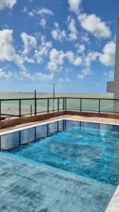 a swimming pool with a view of the beach at Niníve Boutique Hotel in Cabedelo