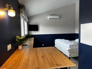 a living room with a wooden table and a bed at Studio Céleste - Clim - Parking gratuit - Proche CNPE Blayais in Braud-et-Saint-Louis
