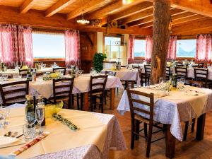 a dining room with tables and chairs and windows at La Fontanella in Montecchia di Crosara