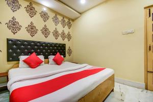 a bedroom with a large bed with red pillows at Super Hotel O Priyal Amrit Sagar in Rourkela