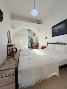 ein Schlafzimmer mit einem großen weißen Bett in einem Zimmer in der Unterkunft Volta Stonehouse Apartments in Frátsia