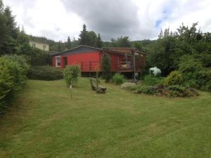 a red house in the middle of a yard at Ferienhaeuser-Am-Eichenberg-Haus-1 in Blankenburg