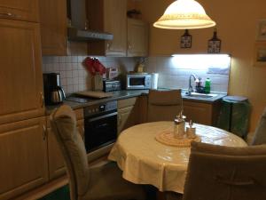 a kitchen with a table and chairs and a kitchen with a sink at Ferienhaeuser-Am-Eichenberg-Haus-1 in Blankenburg